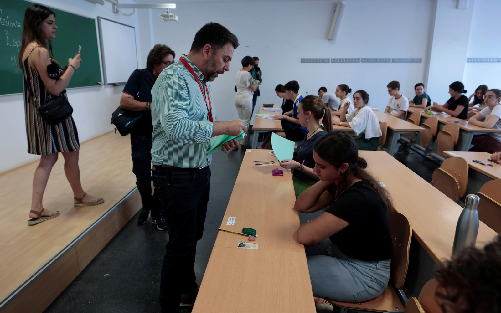 Un profesor reparte exámenes de Selectividad en la Universidad de Sevilla.