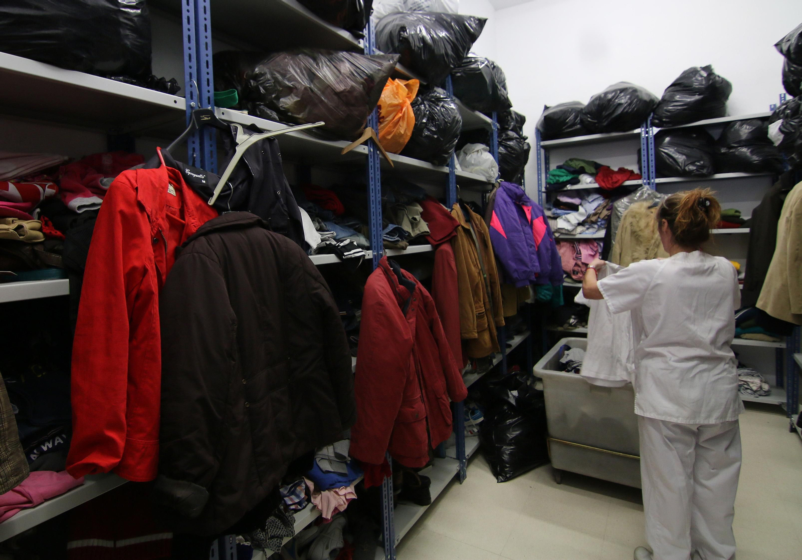 Una trabajadora prepara algunos catres.