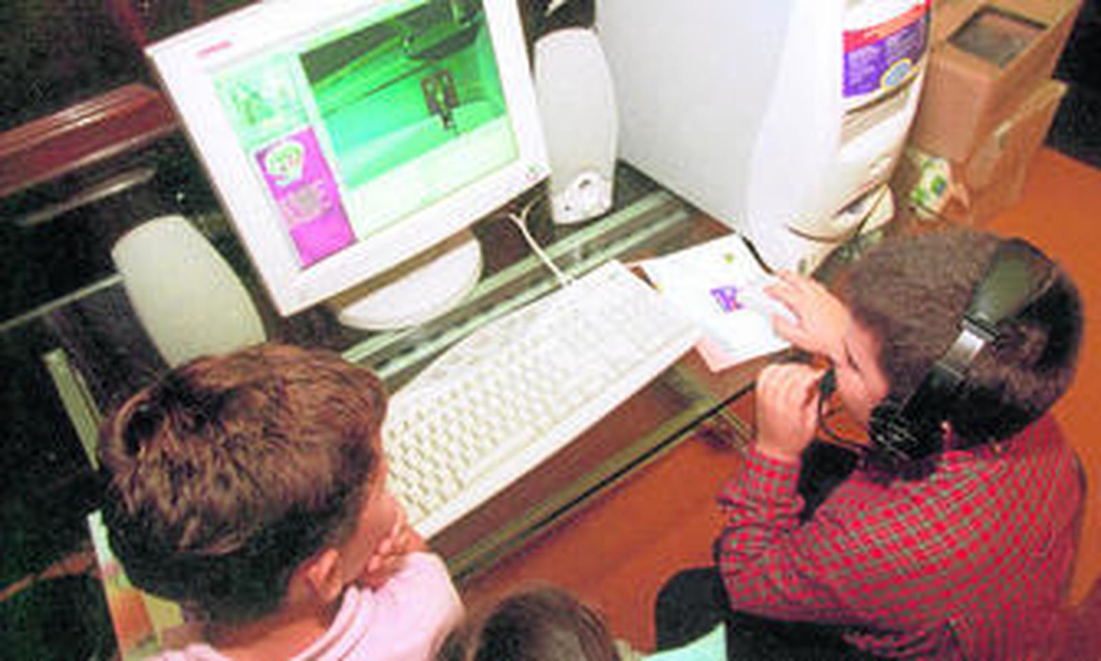 Dos niños juegan con un ordenador.