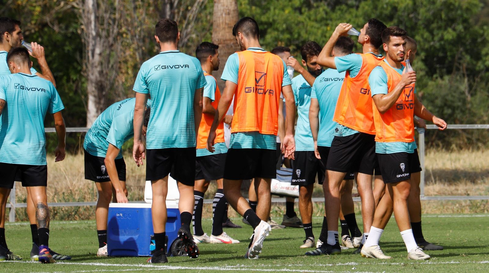 Los jugadores del Córdoba CF se refrescan en un parón en el entrenamiento.