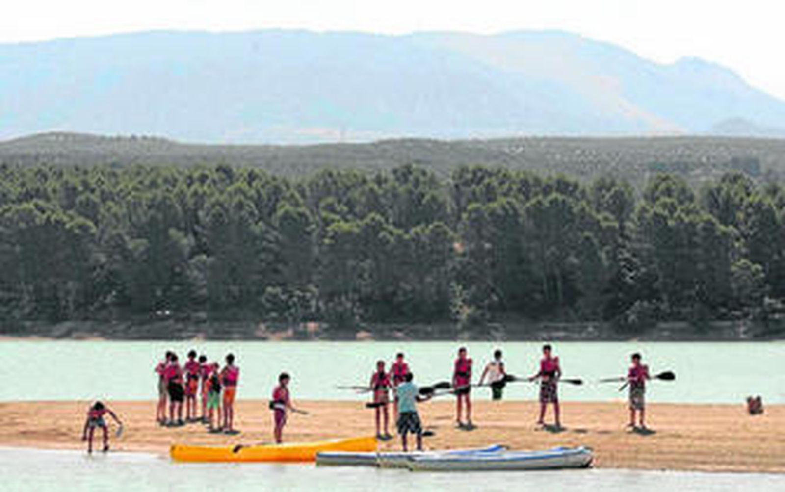 Los monitores explican cómo utilizar un kayac en el embalse, donde se practican deportes multiaventura.