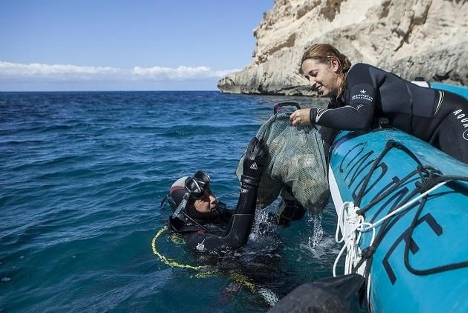 Varios voluntarios del proyecto Libera recogiendo basura del mar.