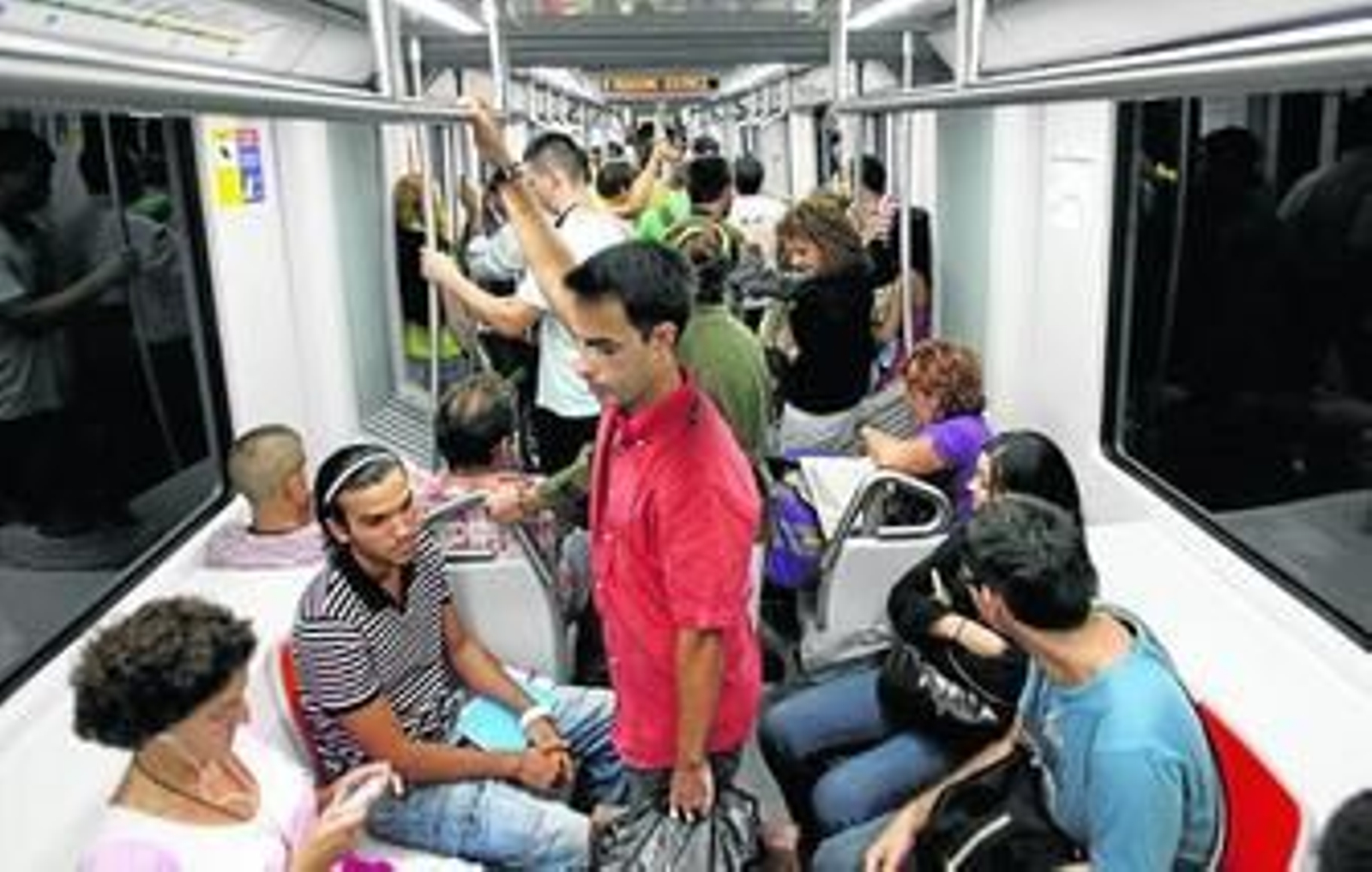 Usuarios del Metro en el interior de uno de los trenes que recorren la línea 1 entre Montequinto y Ciudad Expo, en Mairena del Aljarafe.