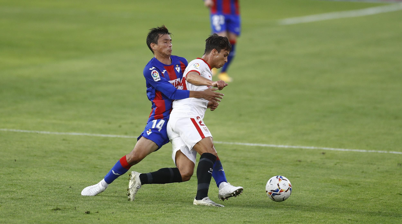 Óliver Torres trata de zafarse de Inui, que lo abraza para impedir su avance.