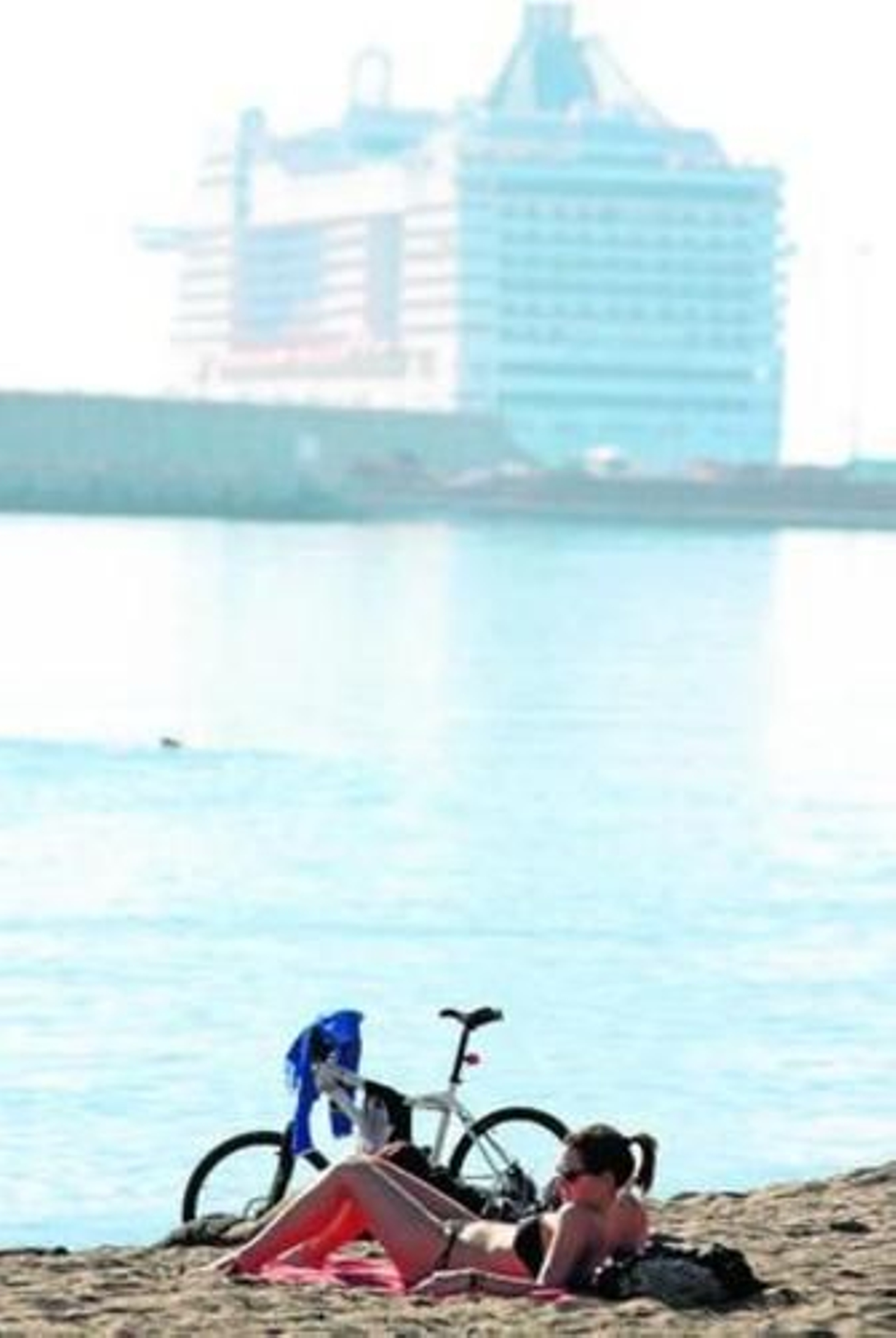 Una joven disfruta de un día de sol en la playa de La Malagueta.