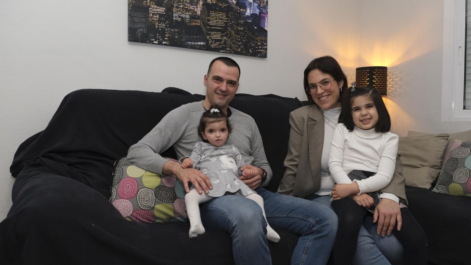 La pequeña María, de 20 meses, junto a sus padres y su hermana en casa