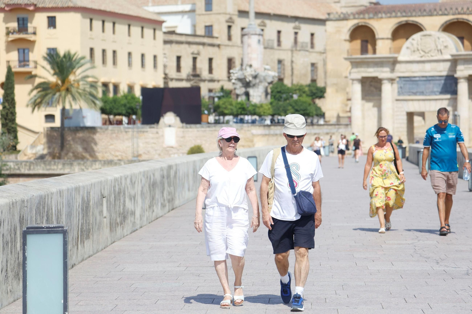 Varias personas caminan por el Puente Romano en verano.