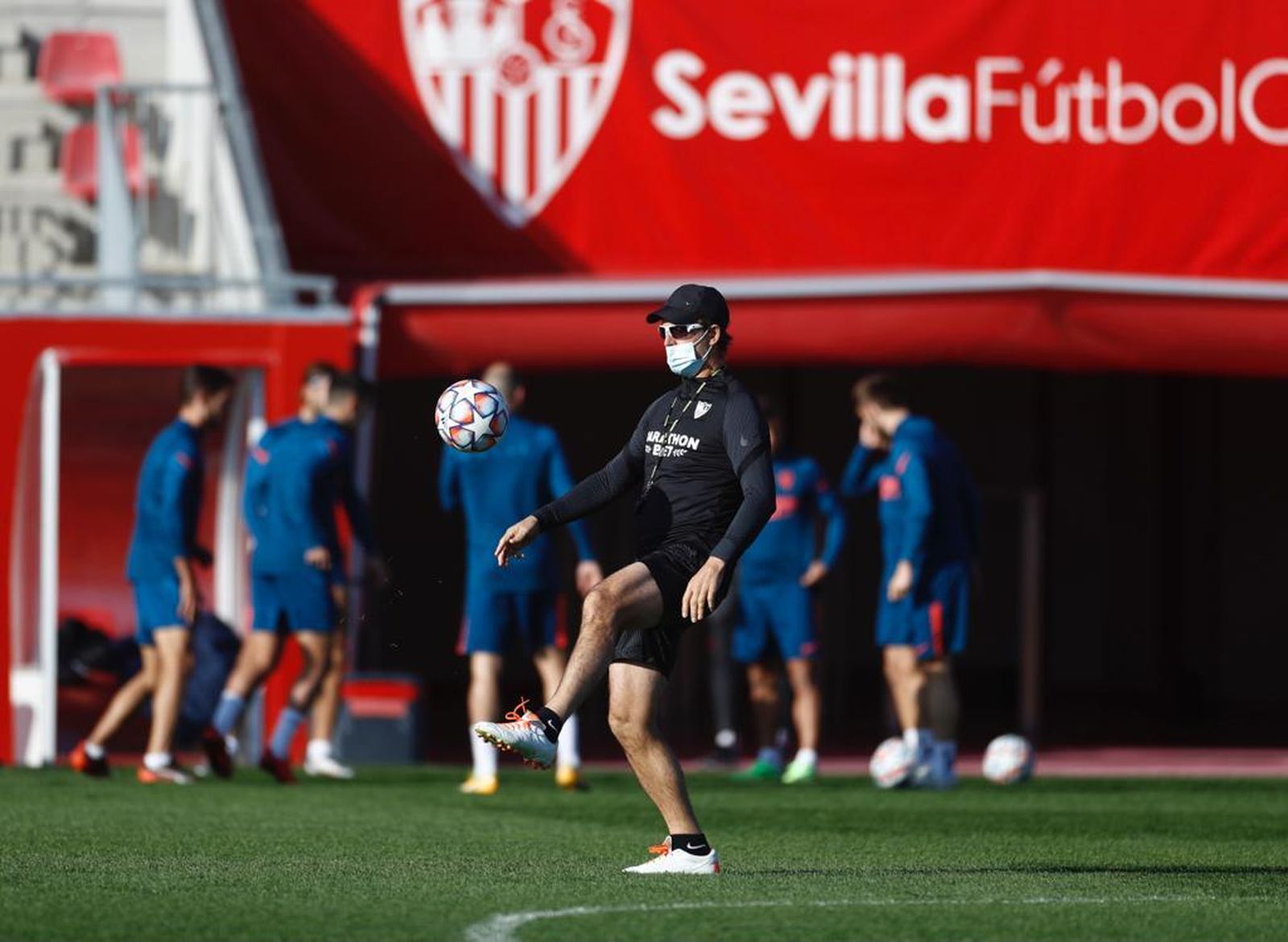 Lopetegui da pataditas al balón mientras los jugadores realizan ejercicios de calentamiento.