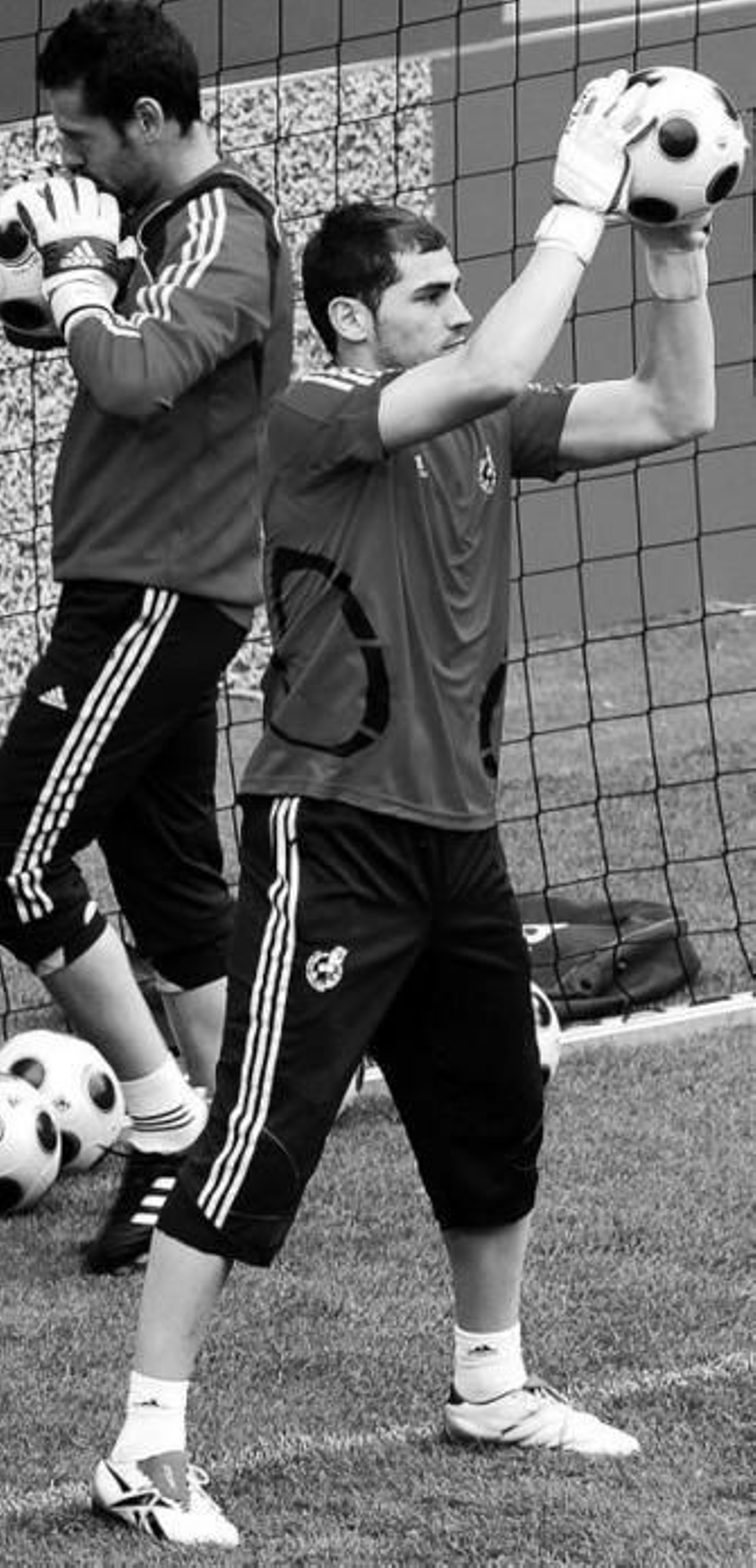 Casillas detiene el balón con Palop a su espalda.