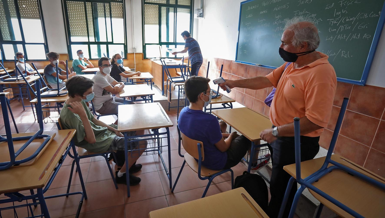 Un docente, tomando la temperatura al alumnado en el Coloma.