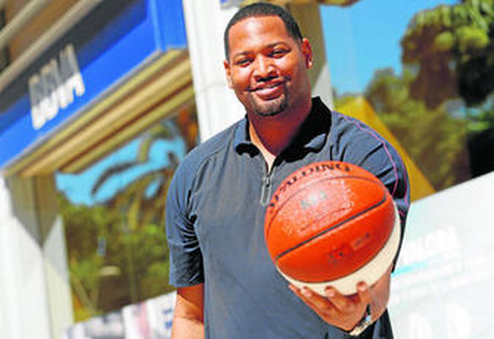 Robert Horry posa con el balón de la NBA, a la entrada de la oficina del banco BBVA de la Avenida Andalucía.