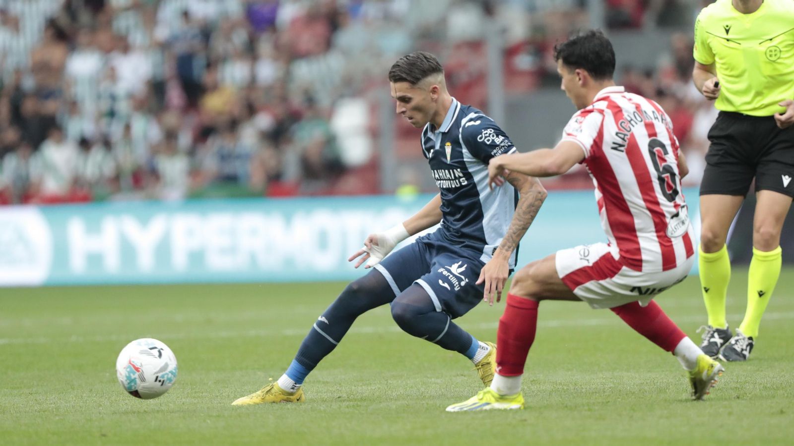 Álex Sala golpea el balón en presencia de Nacho Martín.