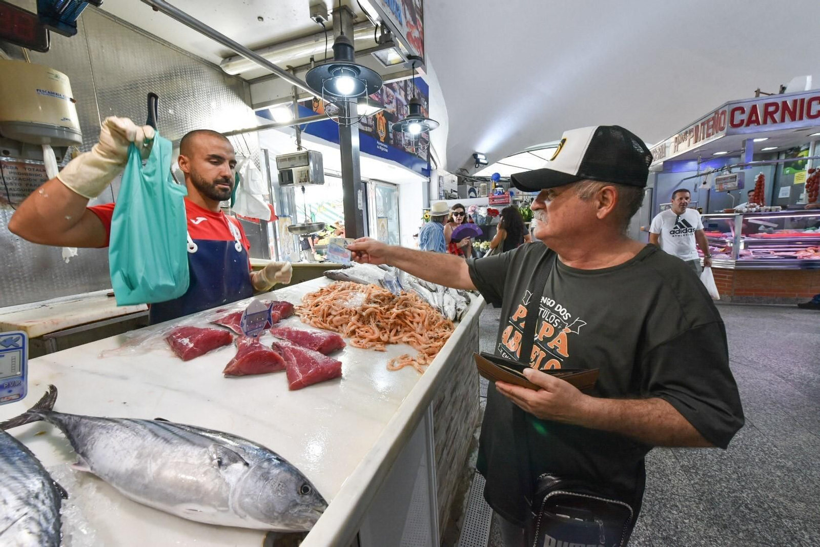 Un comerciante del mercado Ingeniero Torroja atiende a un cliente.