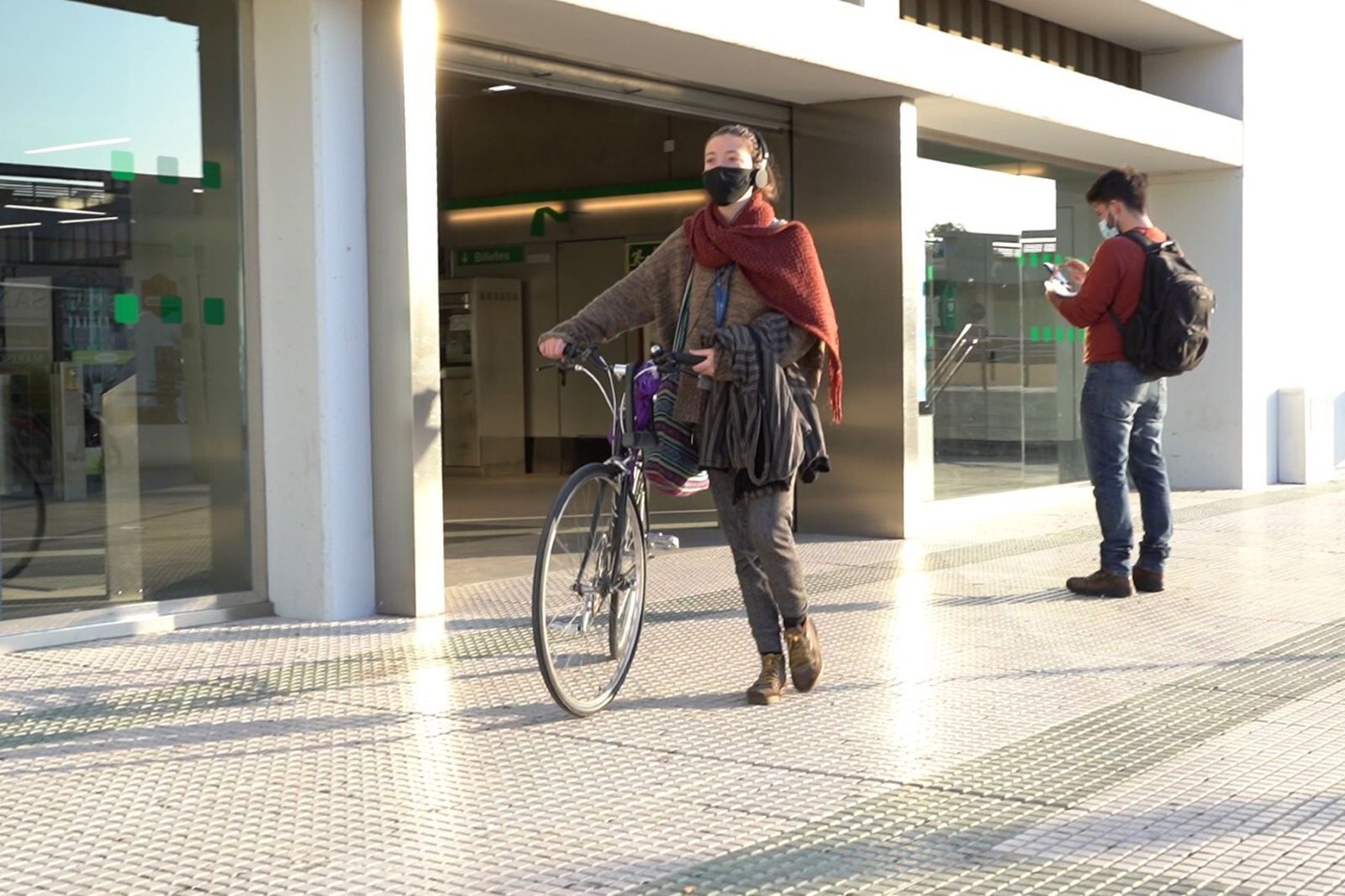 Una joven con bicicleta  a las puertas de una de las dos estaciones de Metro en Mairena del Aljarafe.