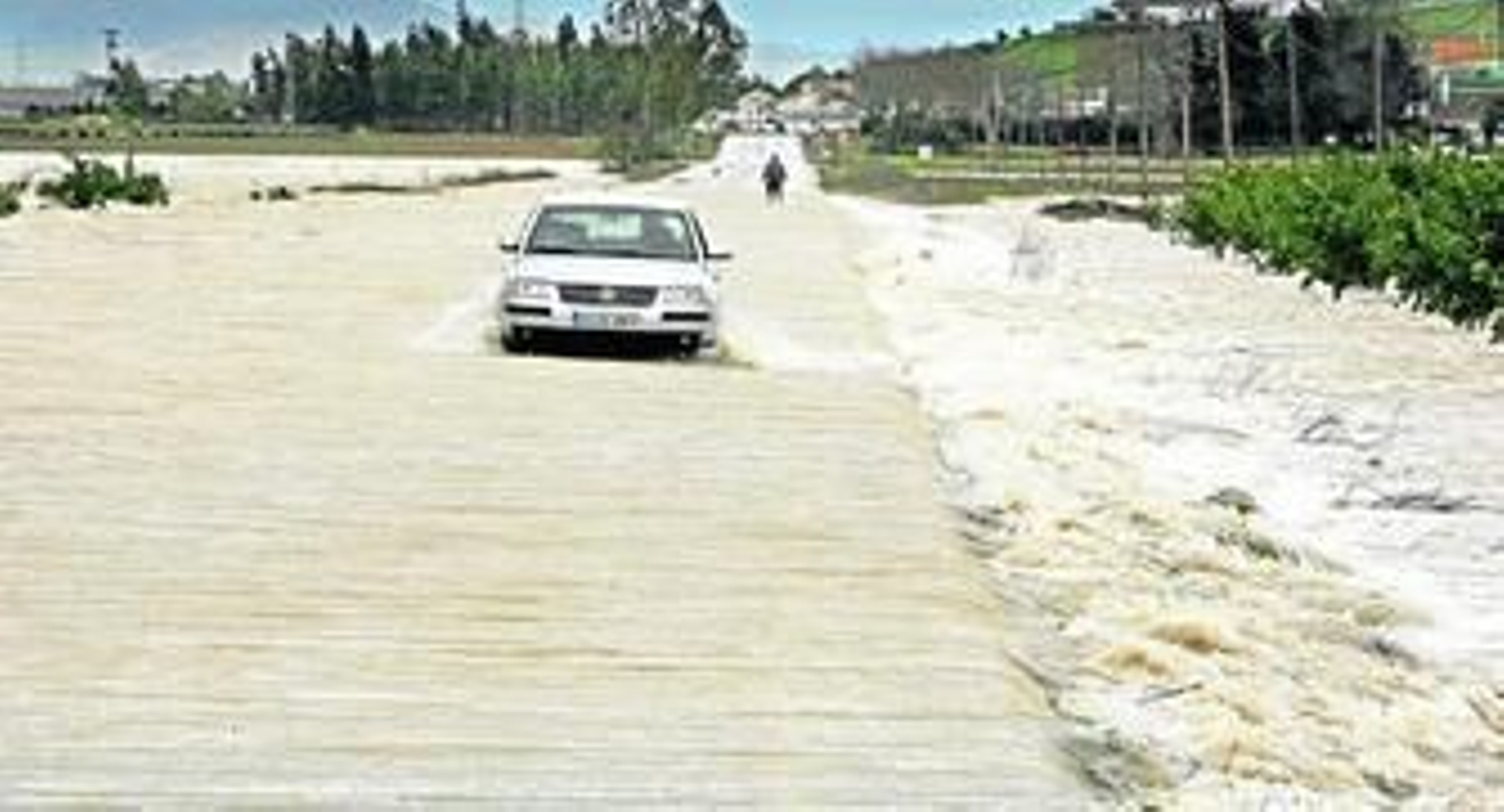 Un coche circula ayer por la carretera de La Ina con dificultades, aunque oficialmente esta vía está cortada.