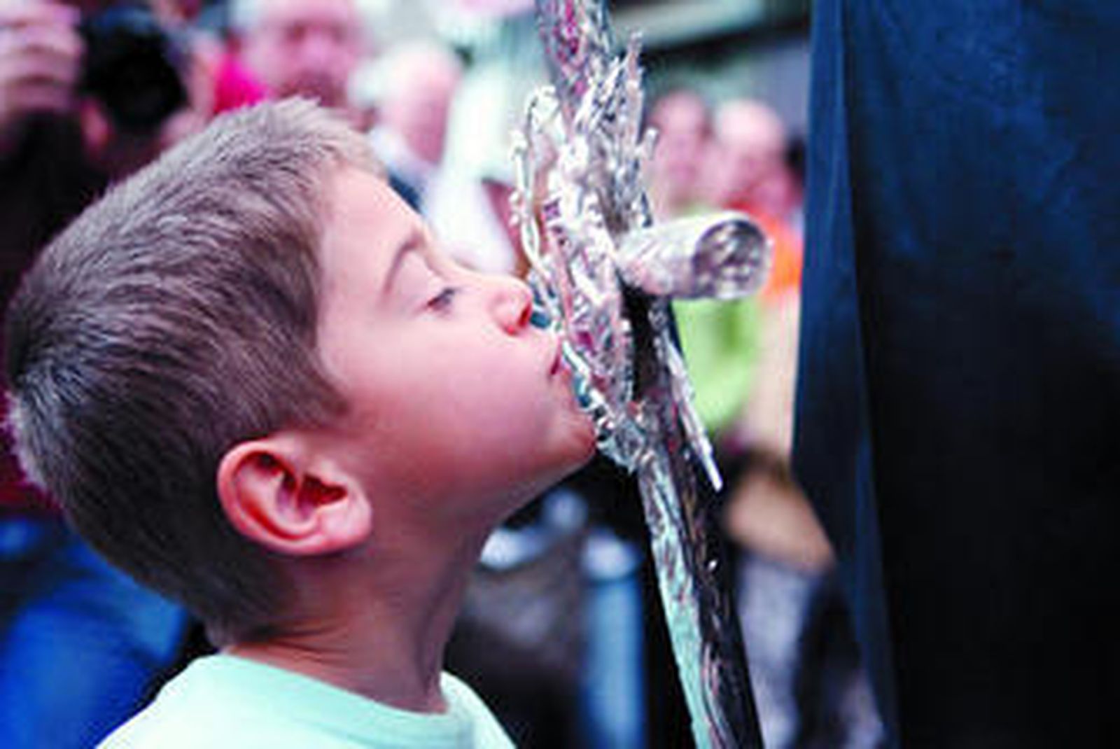 Un niño besa el relicario del Lignum Crucis.