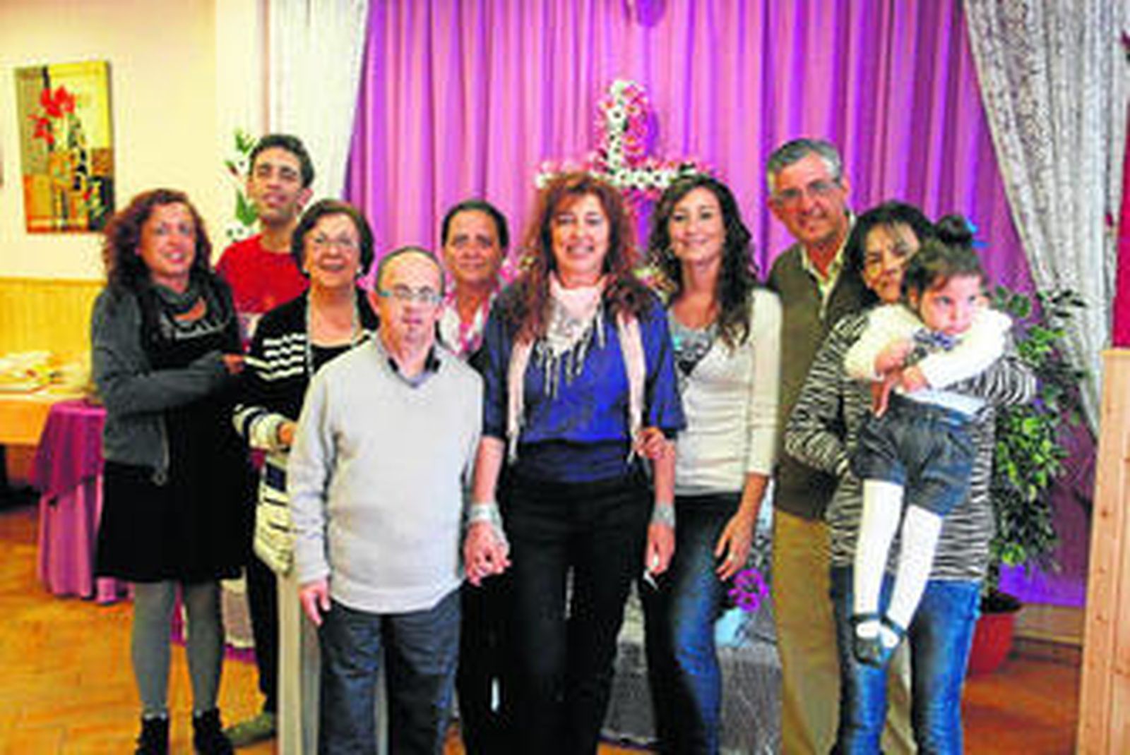 Personal y usuarios de Asansull posan para el fotógrafo de 'Europa Sur' con la cruz de mayo al fondo.