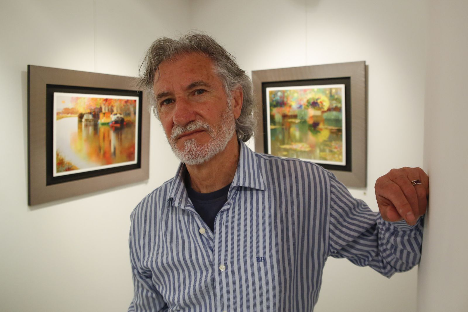 El autor de la exposición, titulada 'Cruce de caminos', posa junto a sus obras.