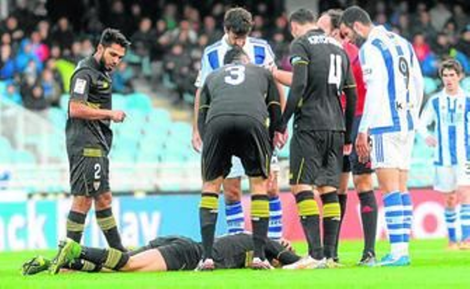 Tremoulinas, Xabi Prieto, Rami, Krychowiak y Agirretxe se interesan por el estado de Andreolli, que se duele tendido en el césped.