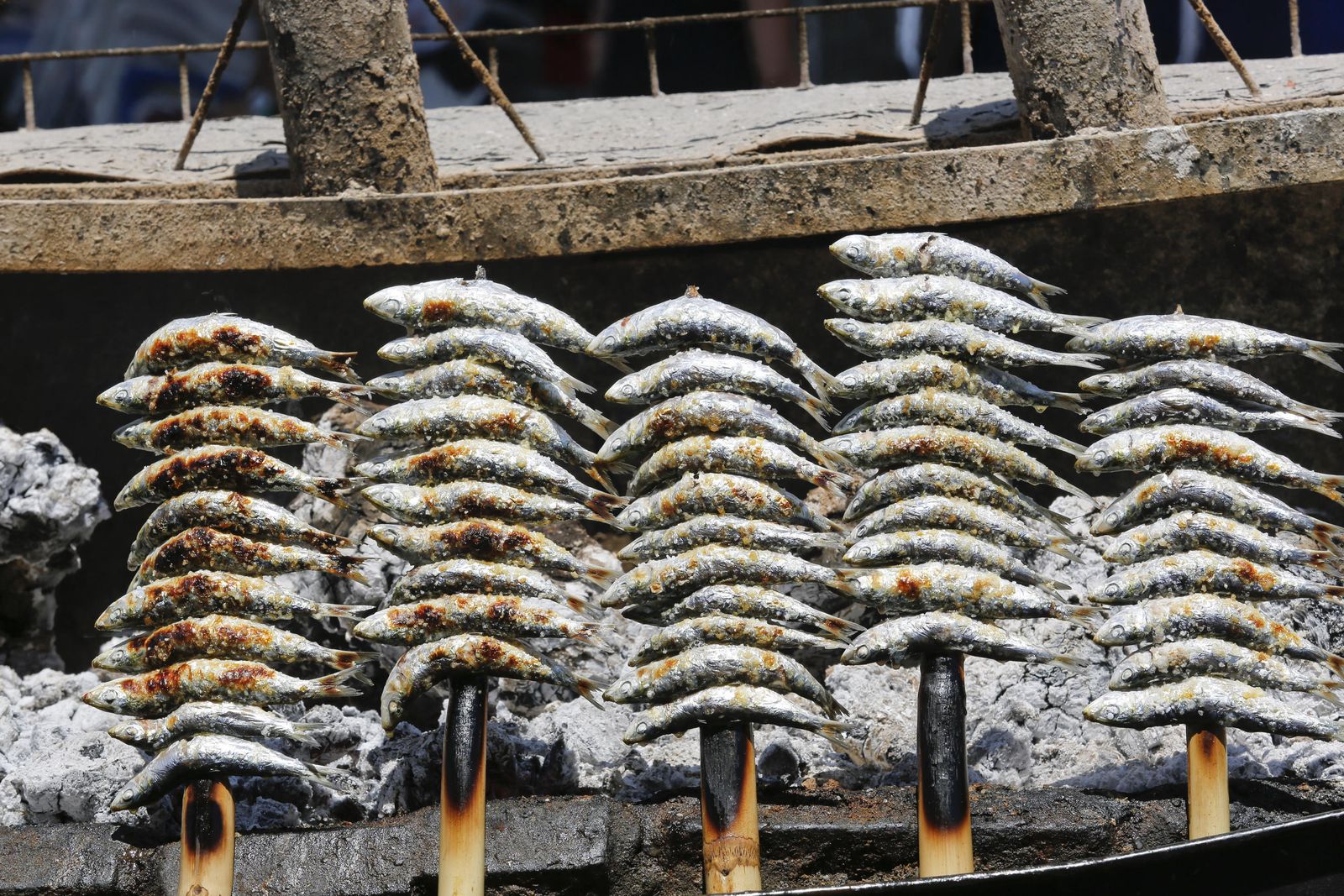 Varios espetos de sardinas en el momento de su elaboración en una barca.