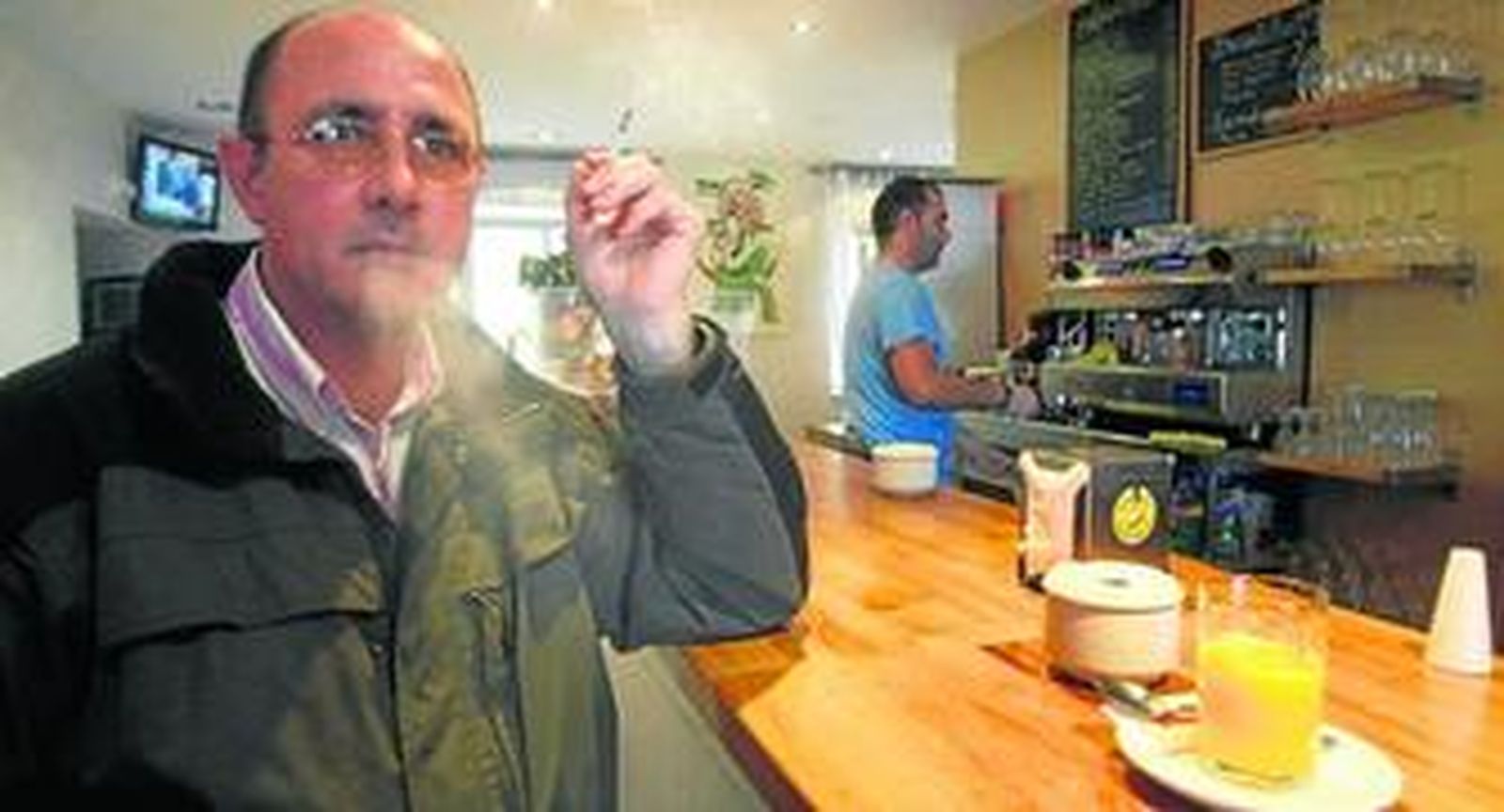 Un cliente fuma uno de los últimos cigarrillos del año, ayer, en el Café Fénix, de Cádiz.