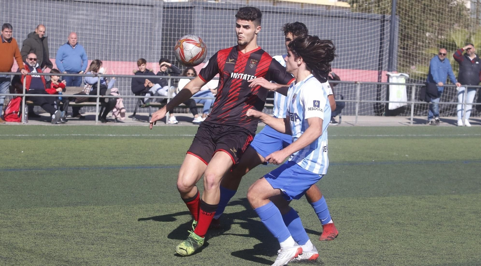 Ignacio pelea con dos jugadores del Málaga.