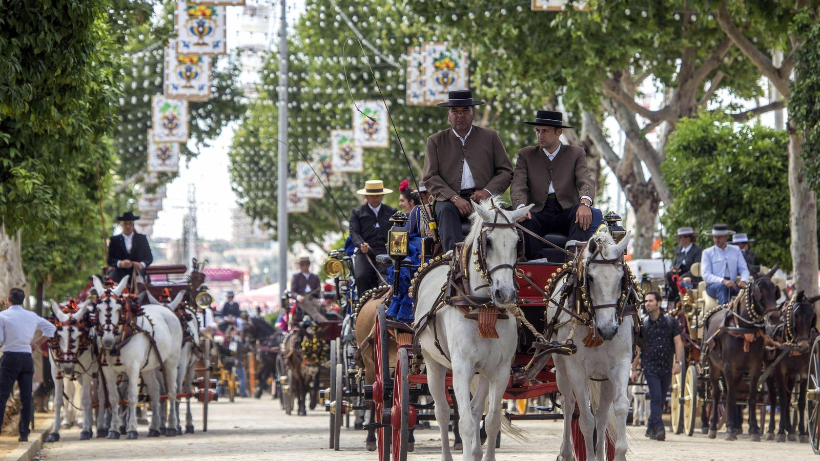 Varios carruajes pasean por el real de la Feria de Sevilla.
