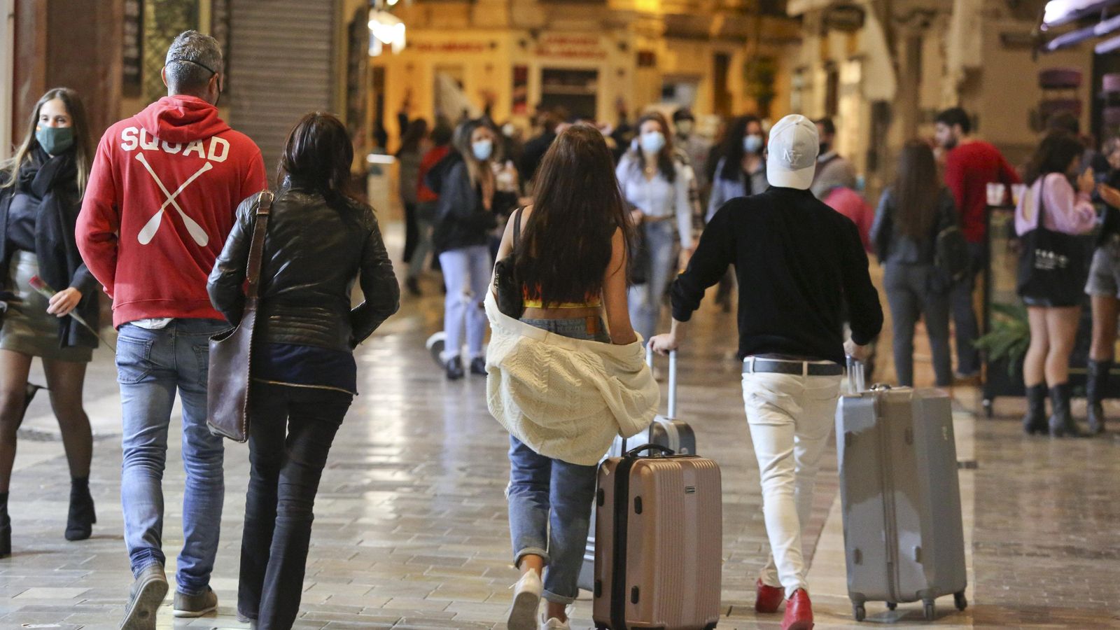 Gente paseando y algunos viajeros en la calle Calderería antes del toque de queda.