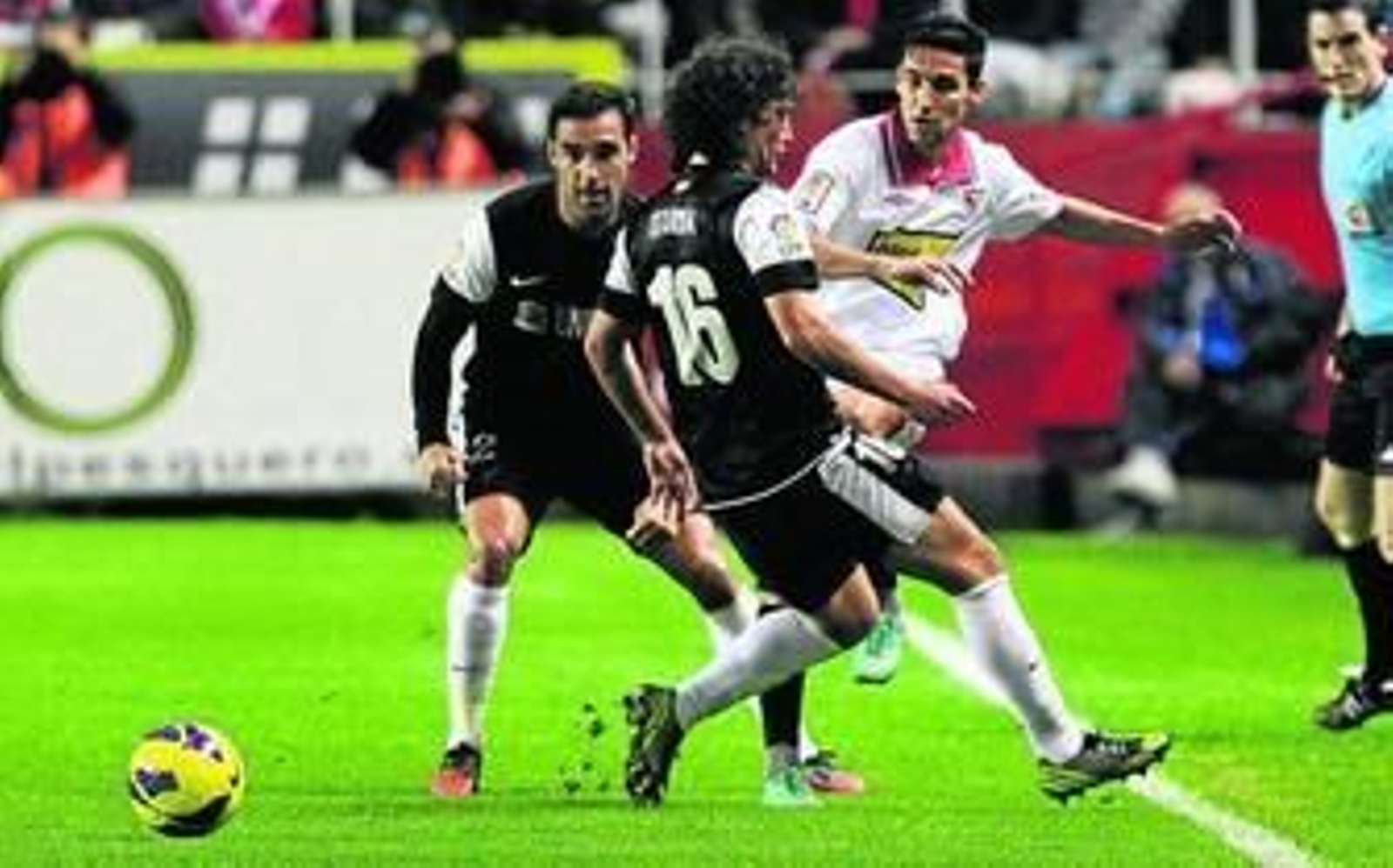 Jesús Navas consigue dar un pase entre Jesús Gámez e Iturra, en un lance del encuentro disputado en el Sánchez-Pizjuán.