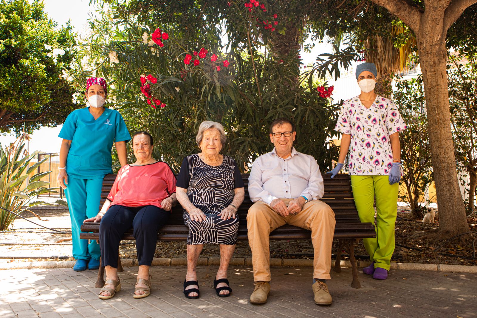 Tres usuarios de la residencia Ciudad de Adra posan junto a sus cuidadoras.