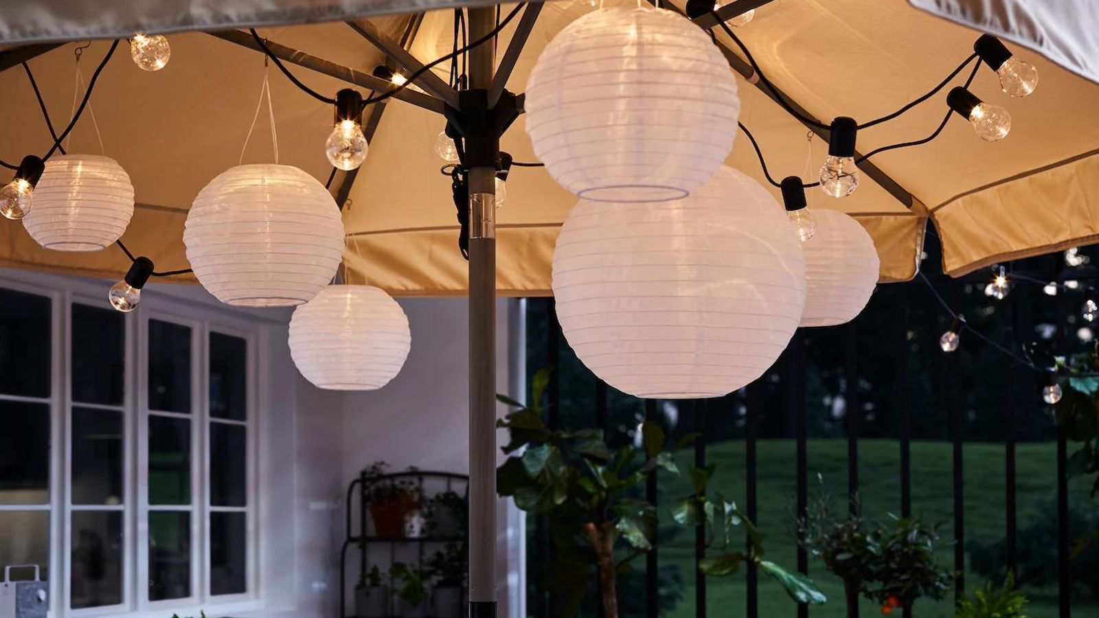 Terraza decorada con farolillos bajo la sombrilla.