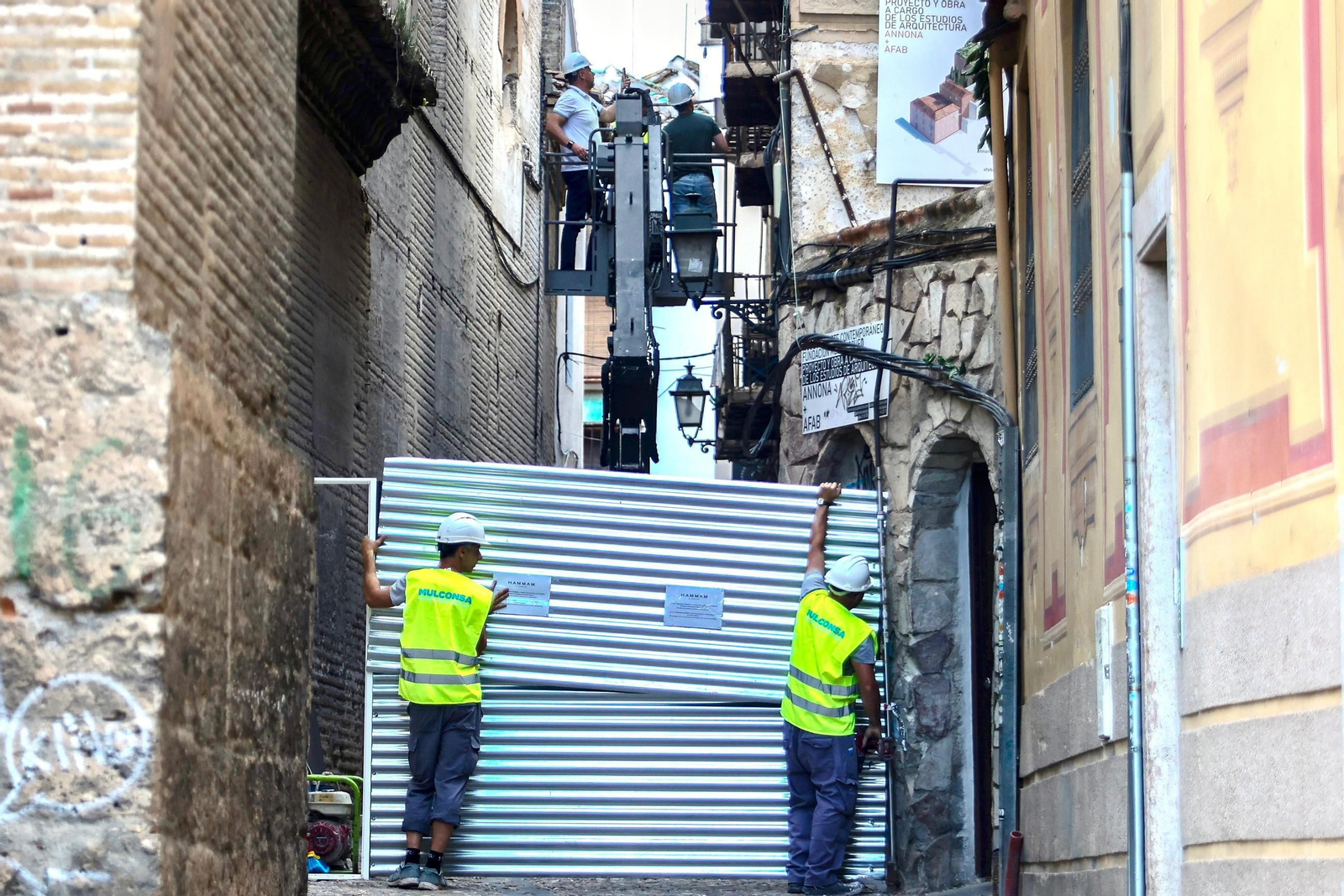 Operarios subidos en la máquina comprobando el estado del inmueble