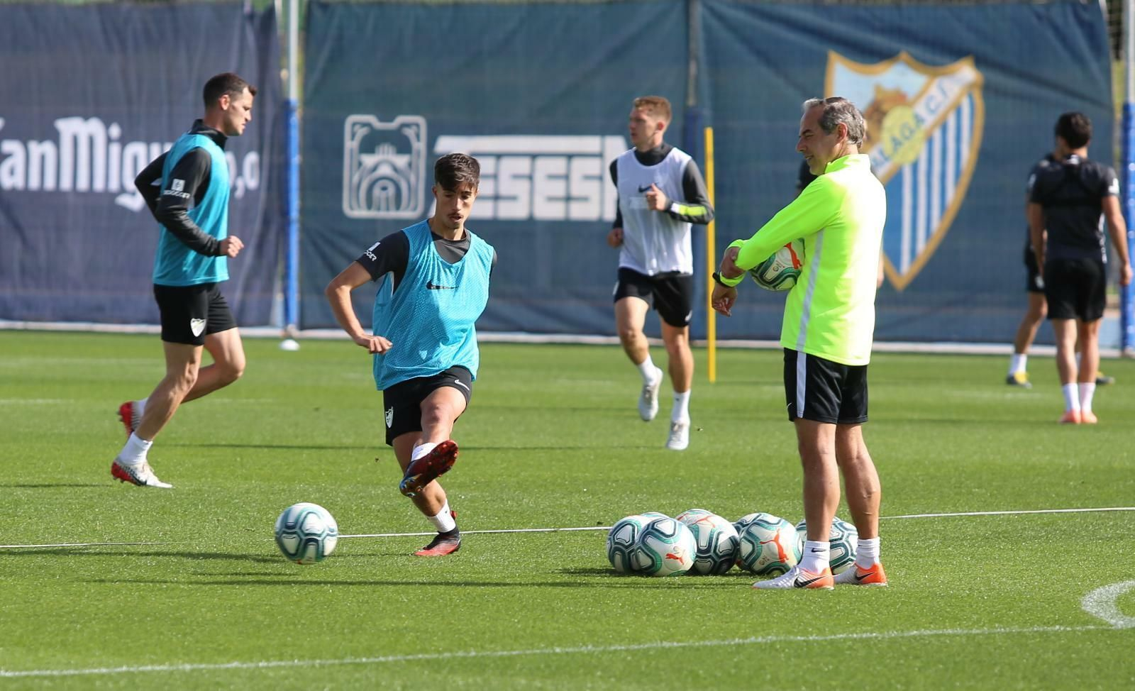 David Larrubia toca el balón observado por Enrique Ruiz.