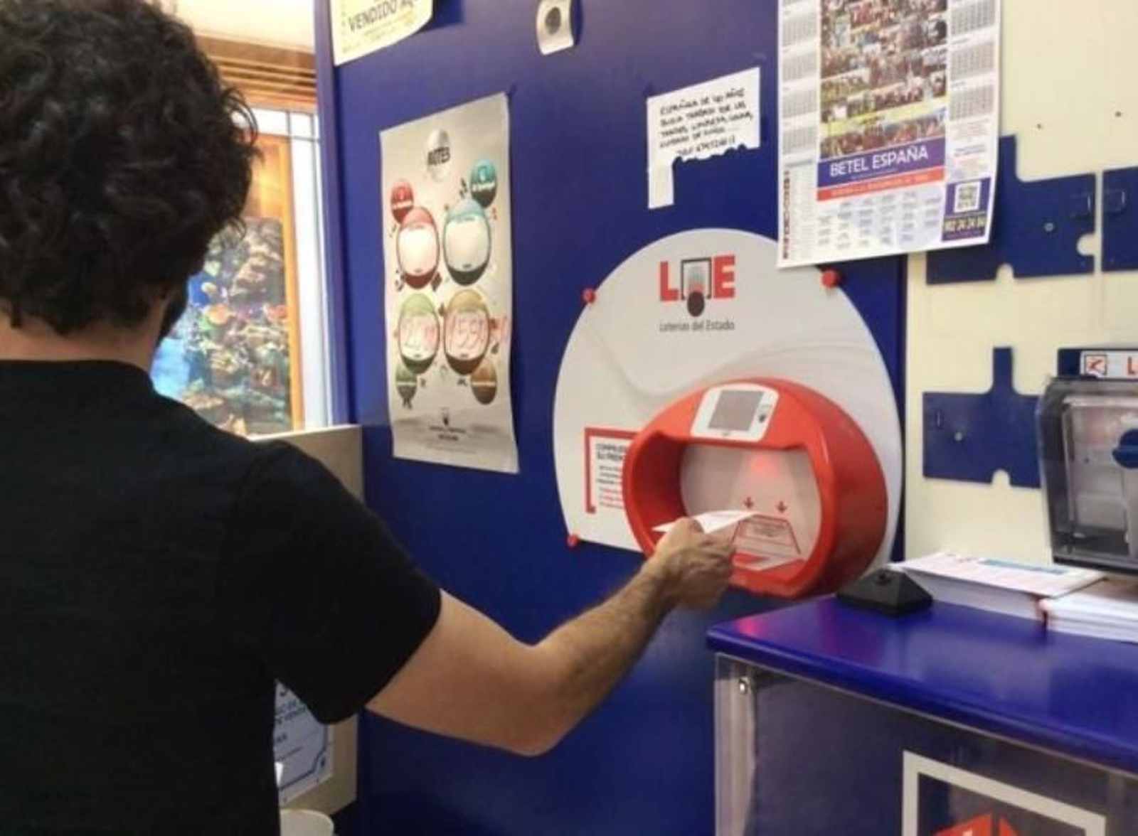 Un hombre comprueba su boleto de lotería.