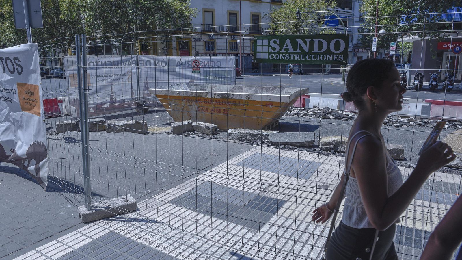 Una joven pasa a la altura de las obras.