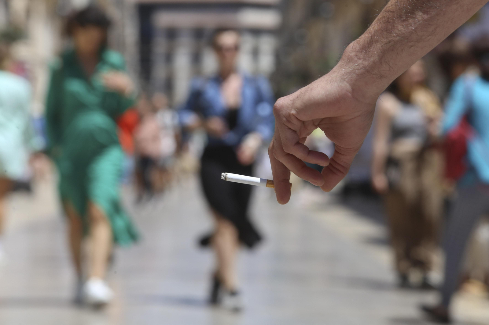 Un fumador, en la calle Larios.