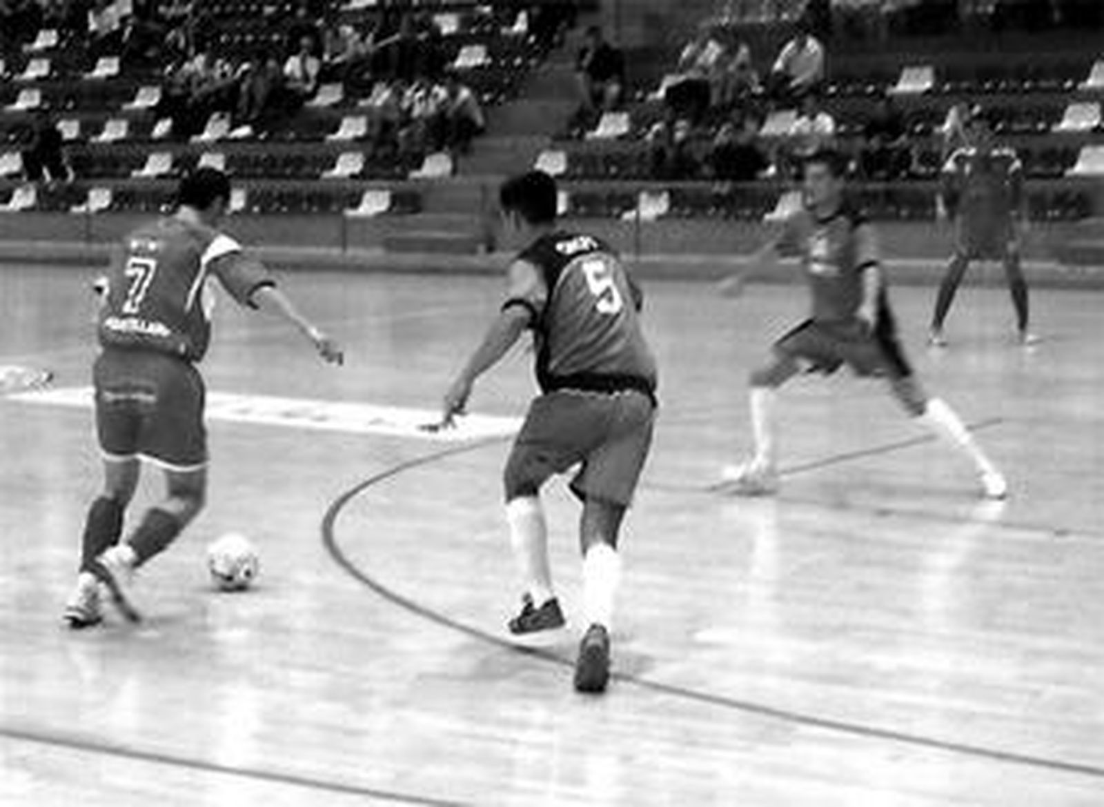 Dos jugadores del Antequera intentan parar a un rival.