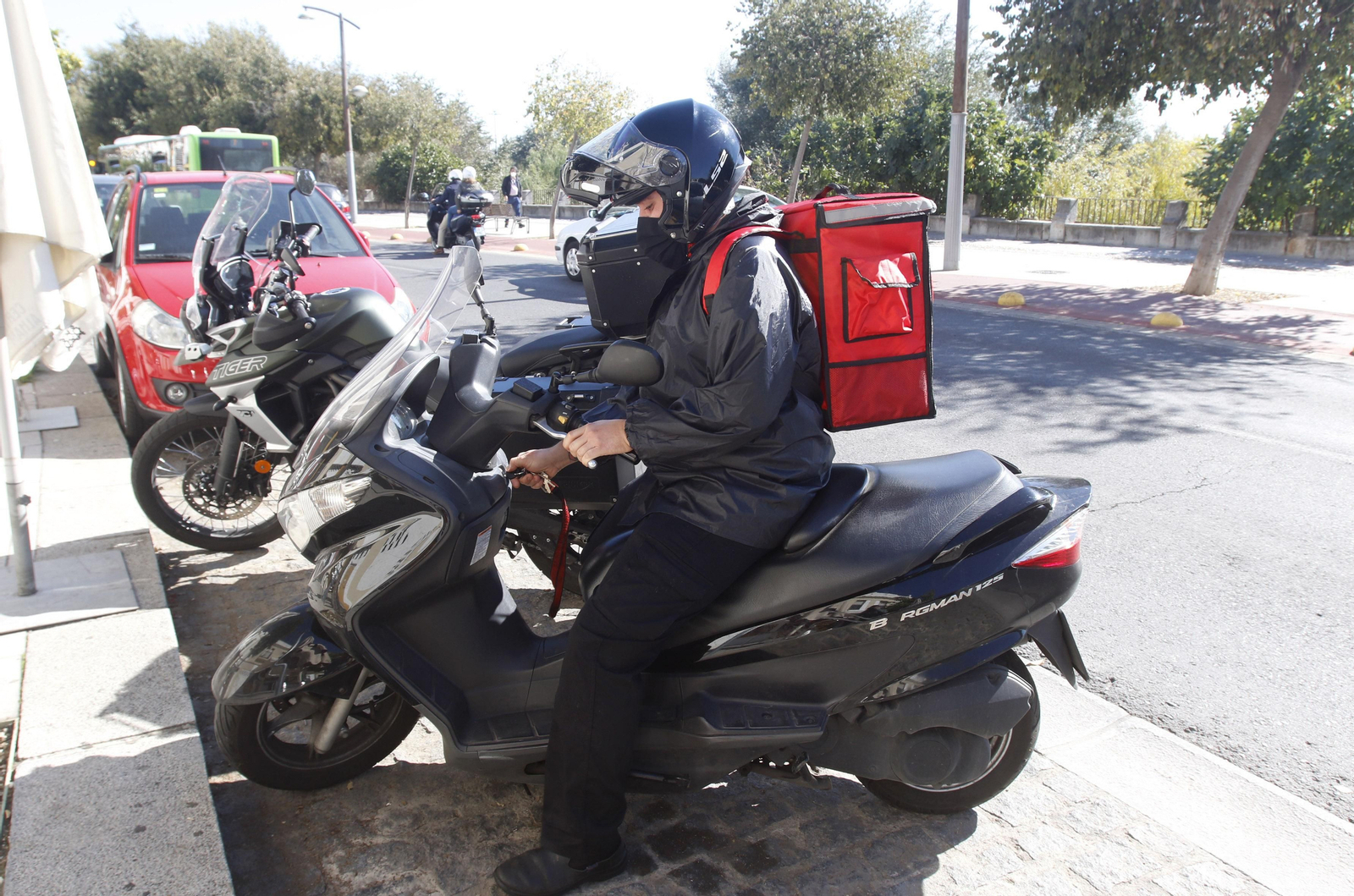Un repartidor en moto en la zona de restaurantes de la Ribera.