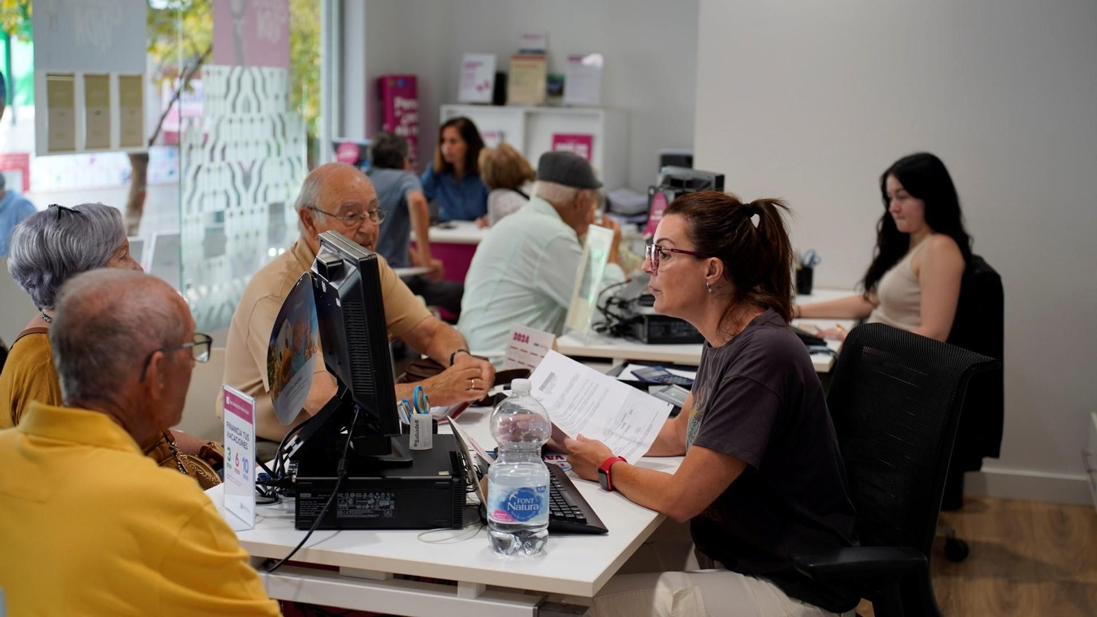 Varios grupos de mayores en la agencia de viajes Nautalia.