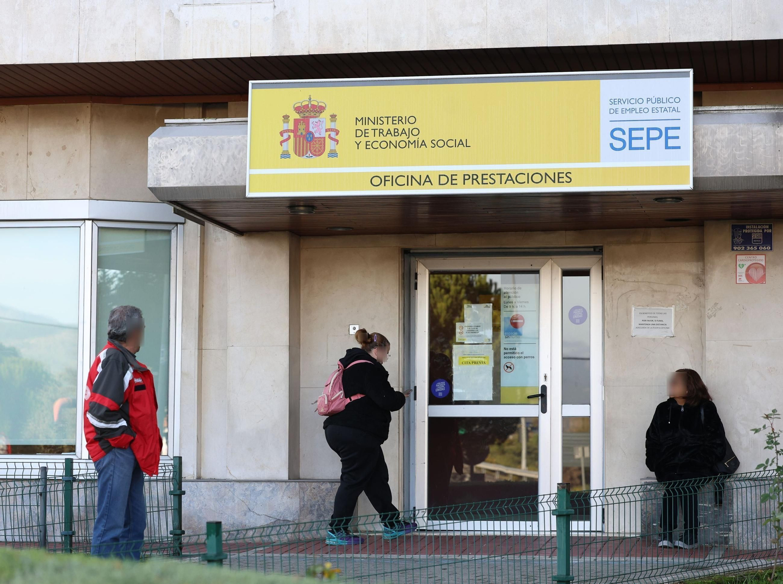 Varias personas en la puerta de una de las oficinas que tiene el SEPE.