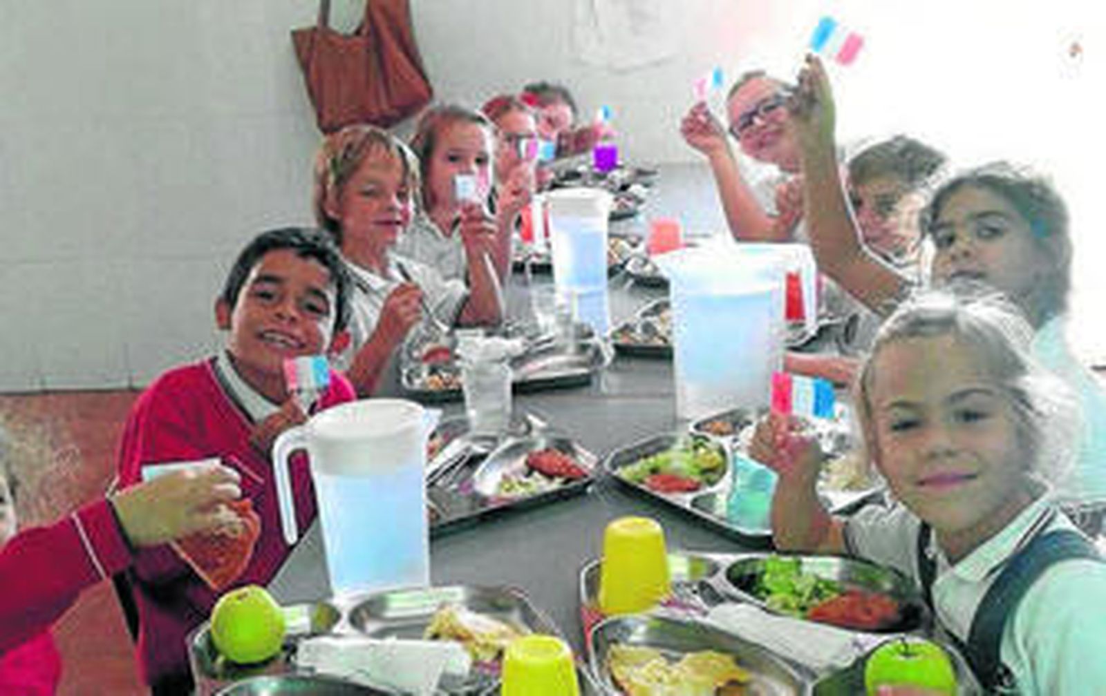 Alumnos del centro en el comedor muestran banderas francesas.