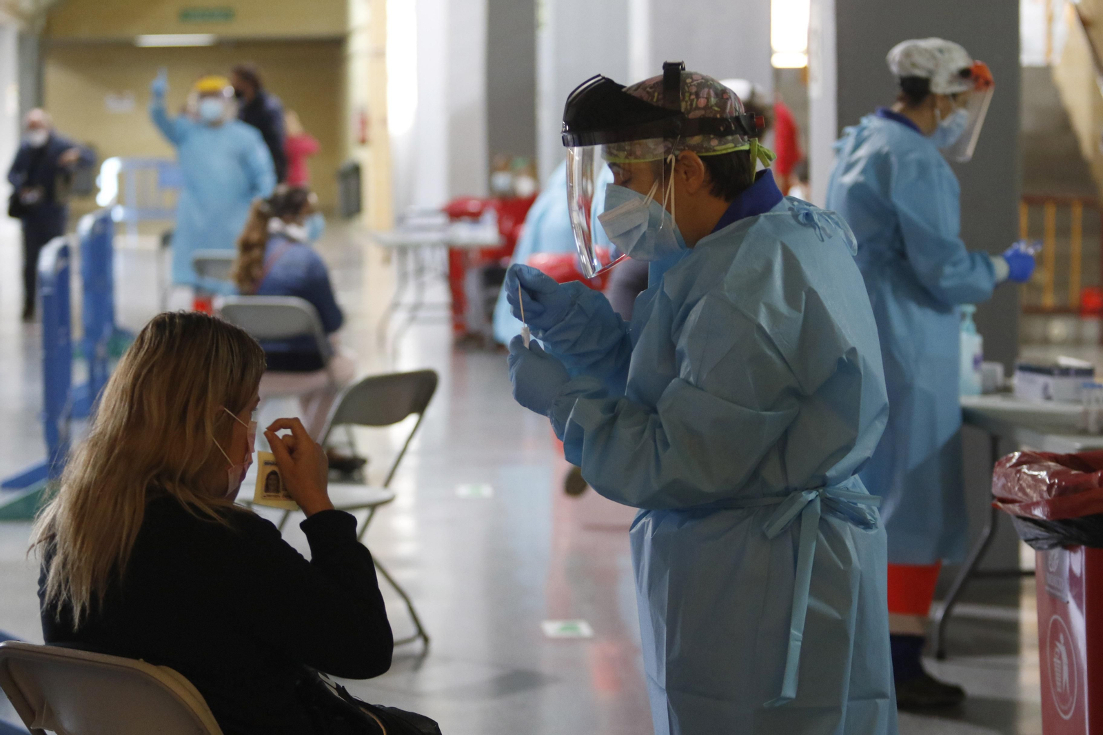 Un profesional sanitario realiza una PCR a una persona. Un profesional sanitario realiza una PCR a una persona.
