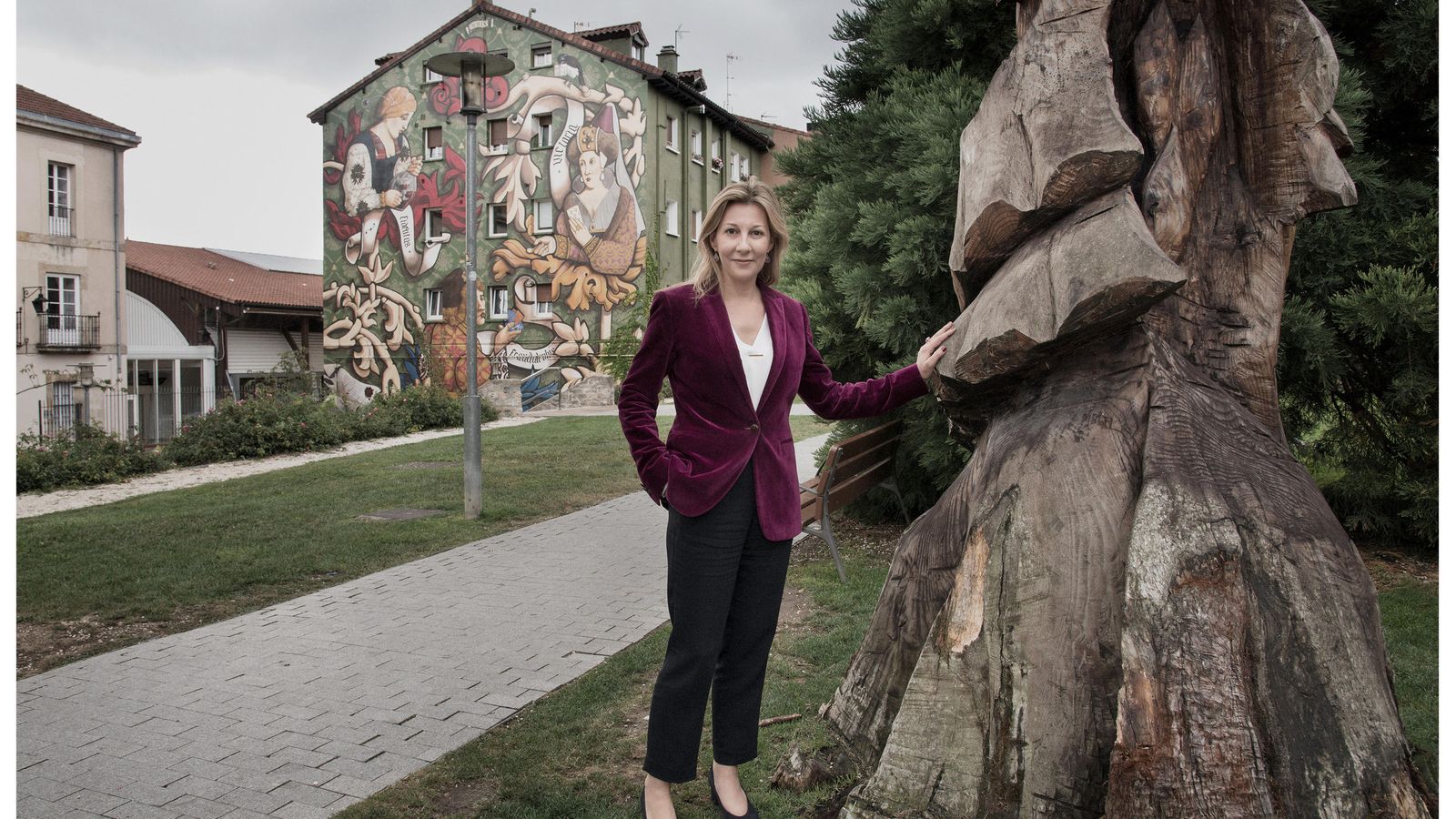 Eva García Sáenz de Urturi (Vitoria, 1972), en el centro de su ciudad natal, con el mural 'El triunfo de Vitoria' al fondo, una pintura callejera que recoge en su nuevo libro.