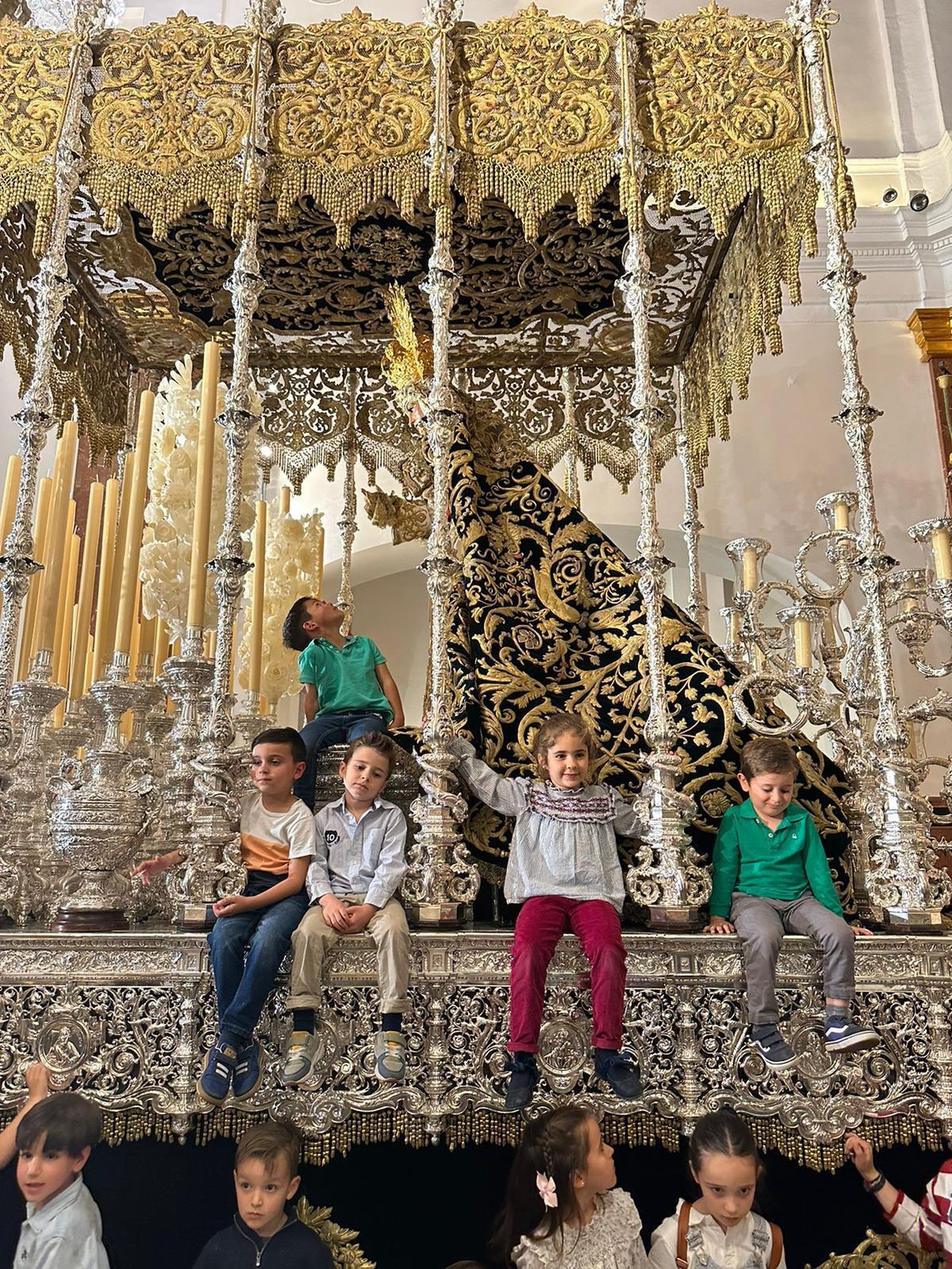 Un grupo de niños subidos al palio de la Esperanza