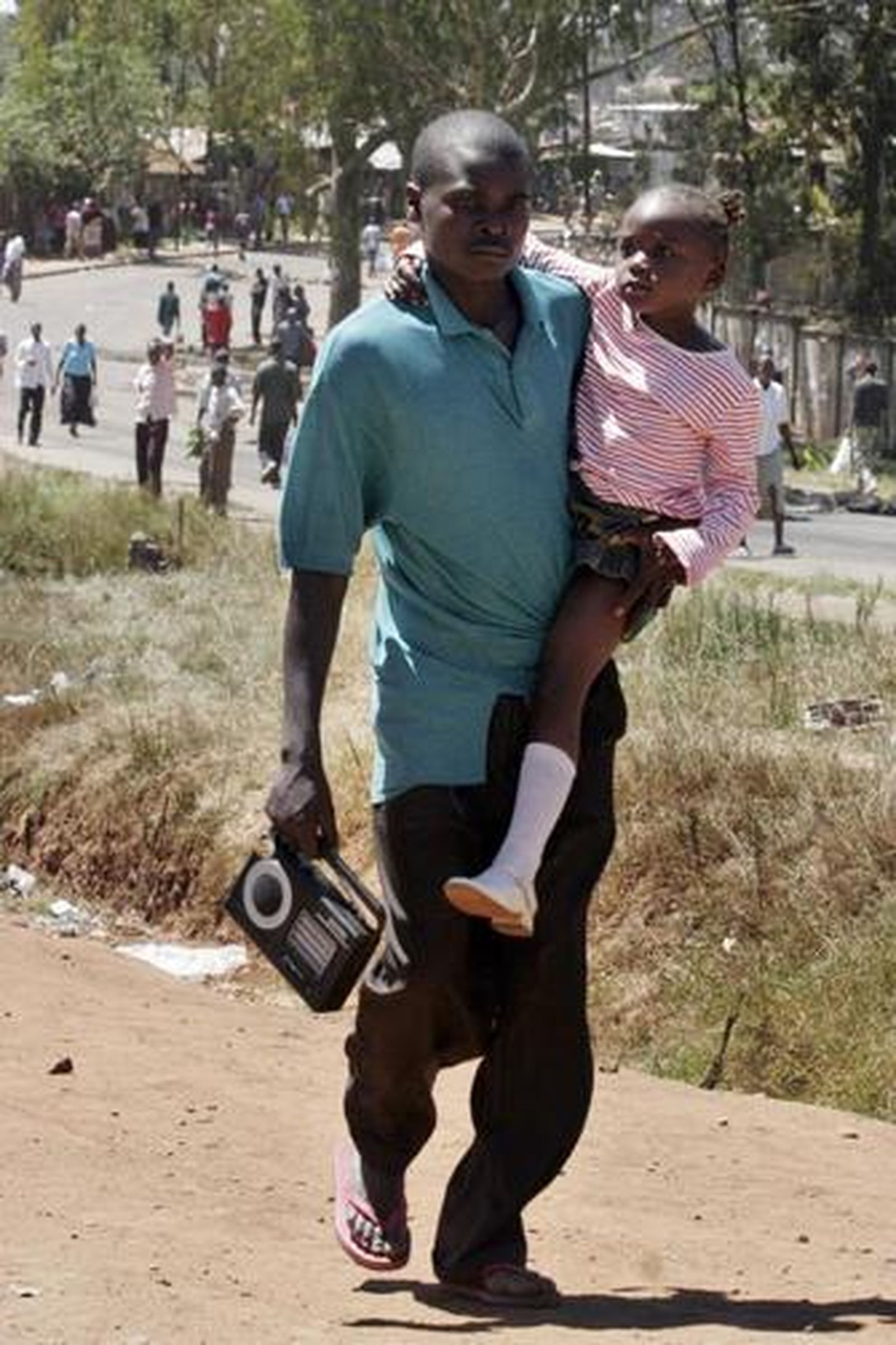 Un hombre escapa de la violencia con su hija en brazos.