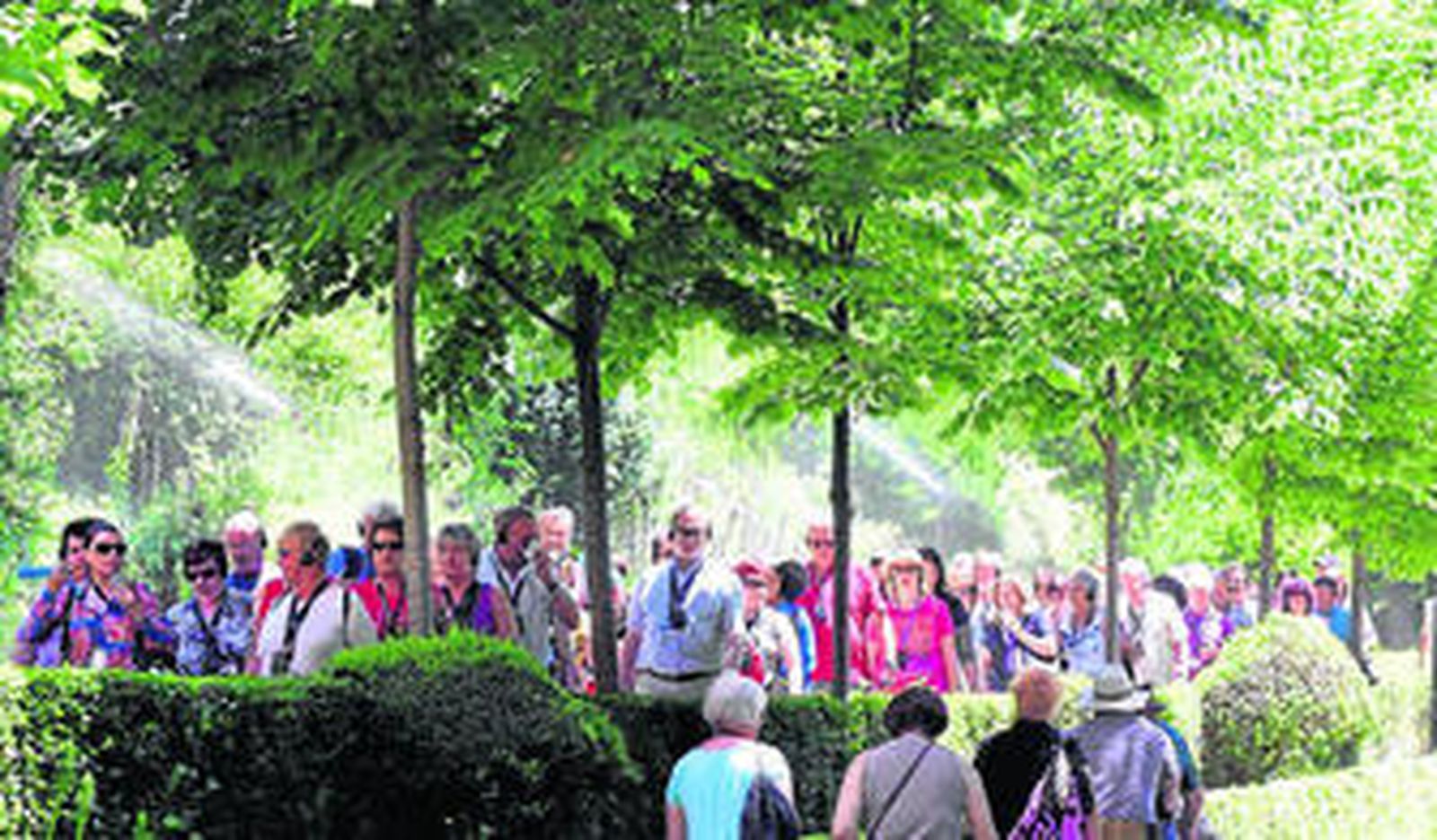 Un grupo de turistas en unos jardines en Granada.