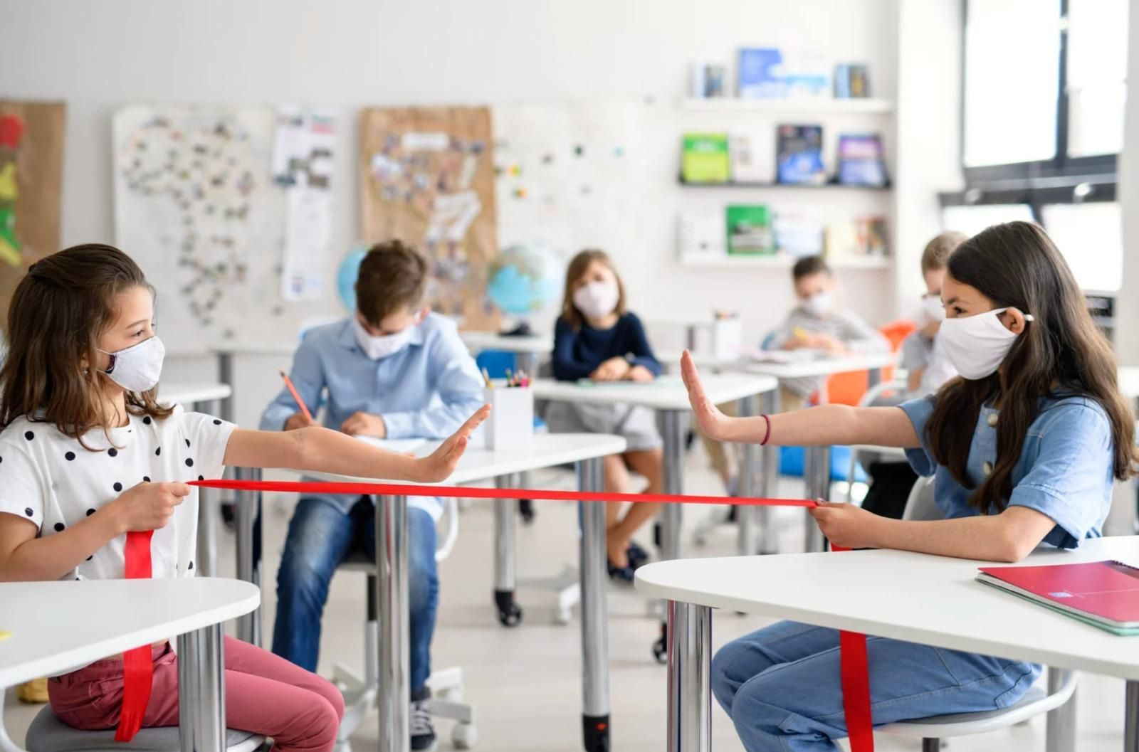 Escolares en un aula aprendiendo a protegerse de la transmisión de virus respiratorios.
