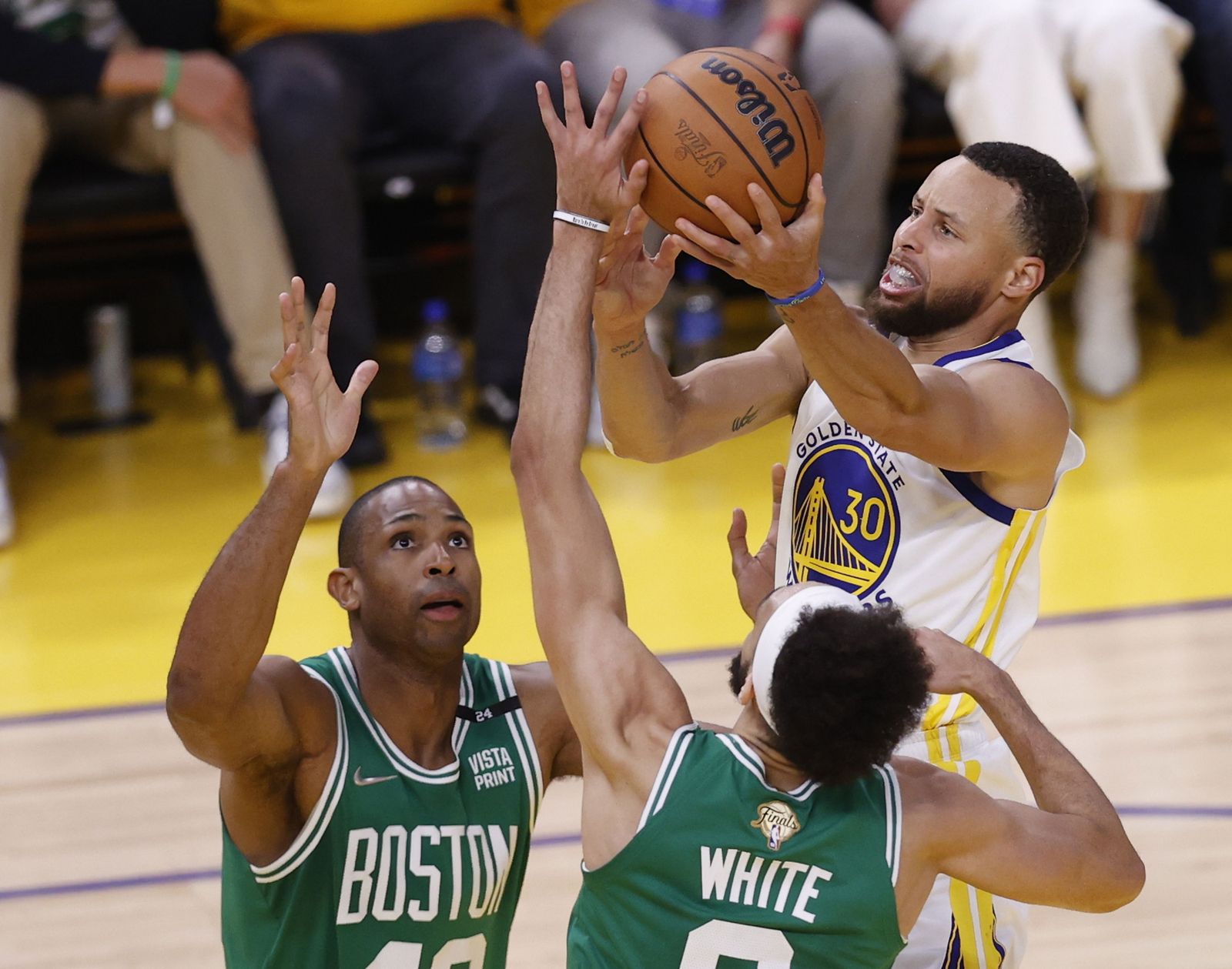 Curry, siempre brillante, lanza por encima de Horford y White.