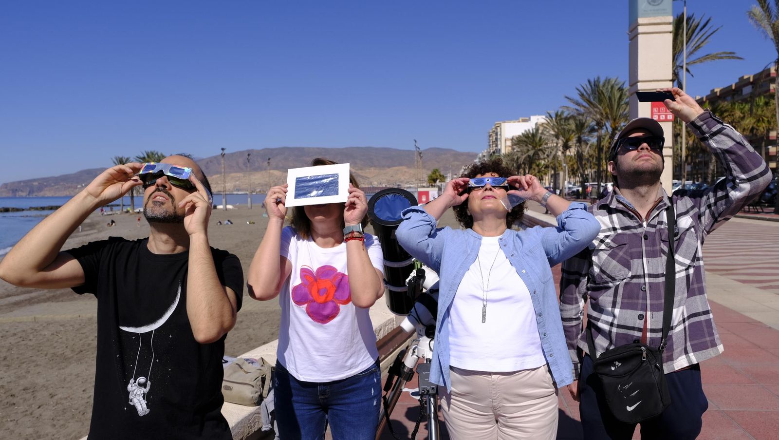 Almería observa el eclipse solar desde el Paseo Marítimo, en imágenes