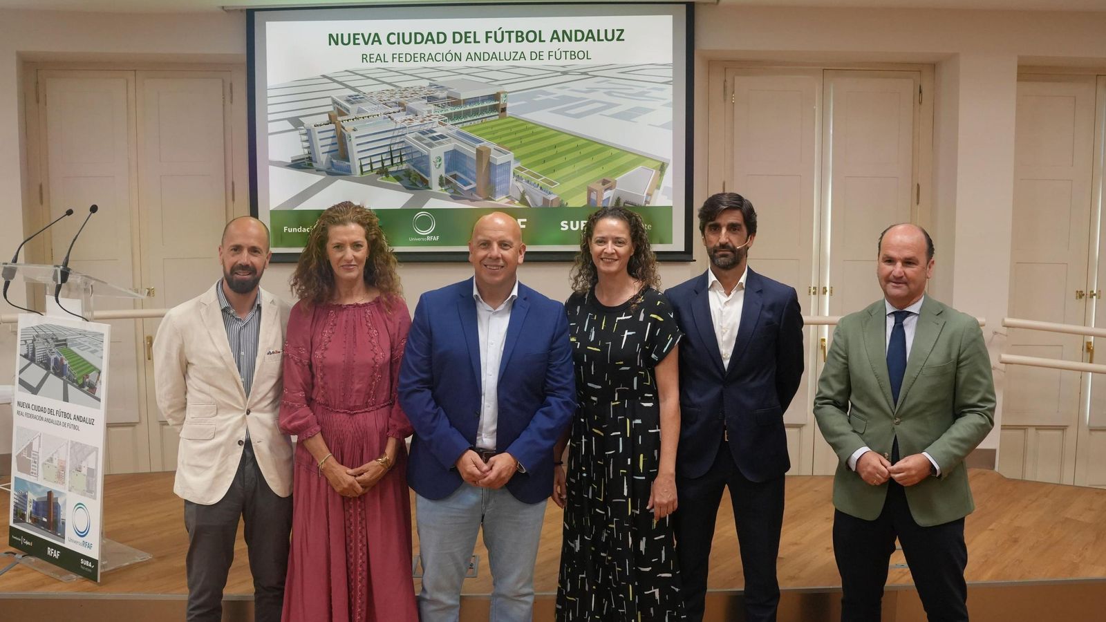Los representantes del proyecto con el presidente de la RFAF, Pedro Curtido a la cabeza y en el fondo la imagen de la Nueva Ciudad del fútbol Andaluz